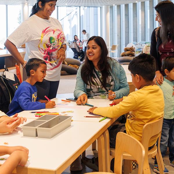 Children and parents colouring in at the tables on Level 4 of the Library.
