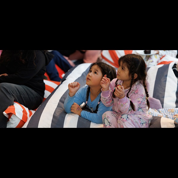 Girls in pyjamas listening to a story.