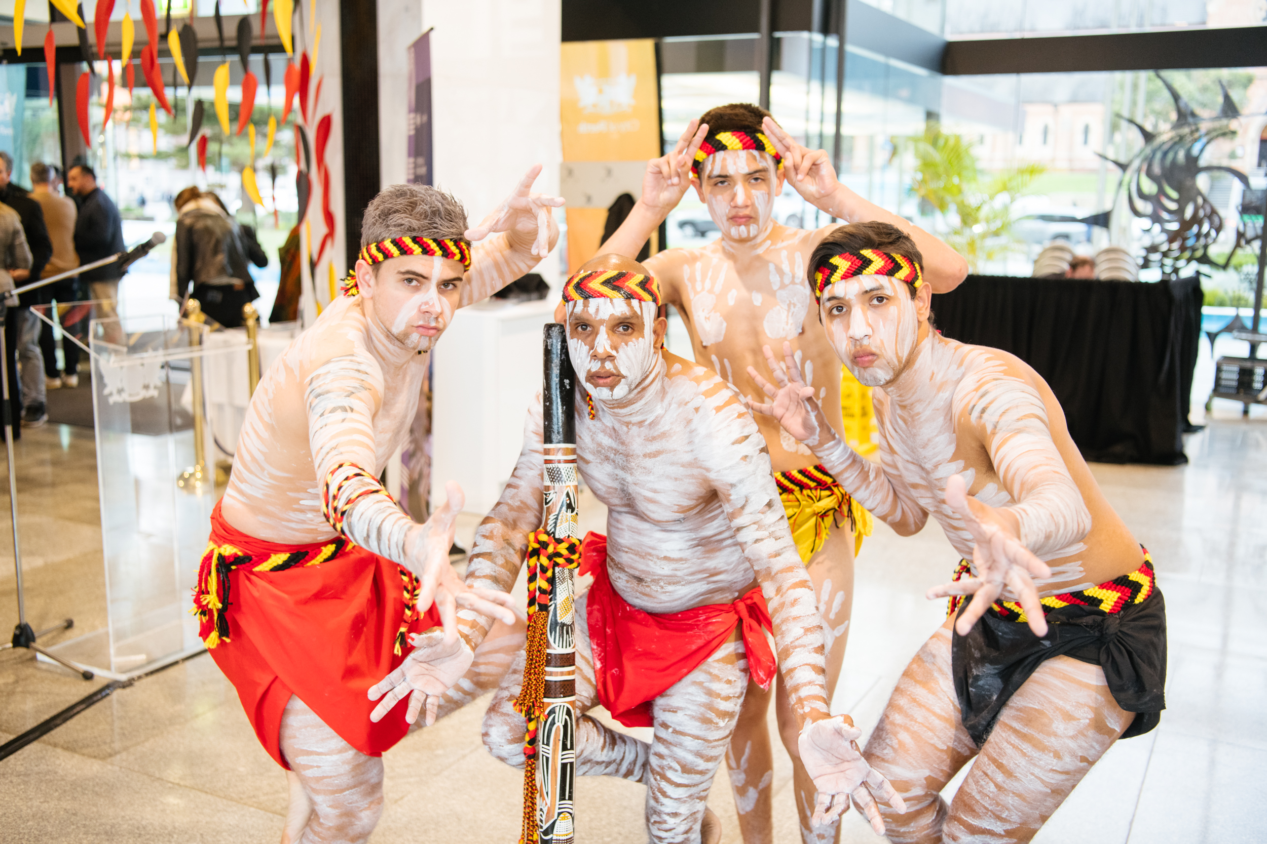 Four Aboriginal dancers with paint and traditional costumes