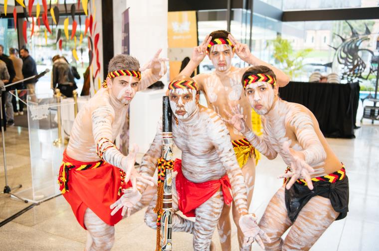 Four Aboriginal dancers with paint and traditional costumes