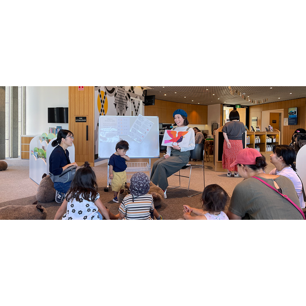 Japanese Storytime at the City of Perth Library, presenter reading picture book to children and parents.