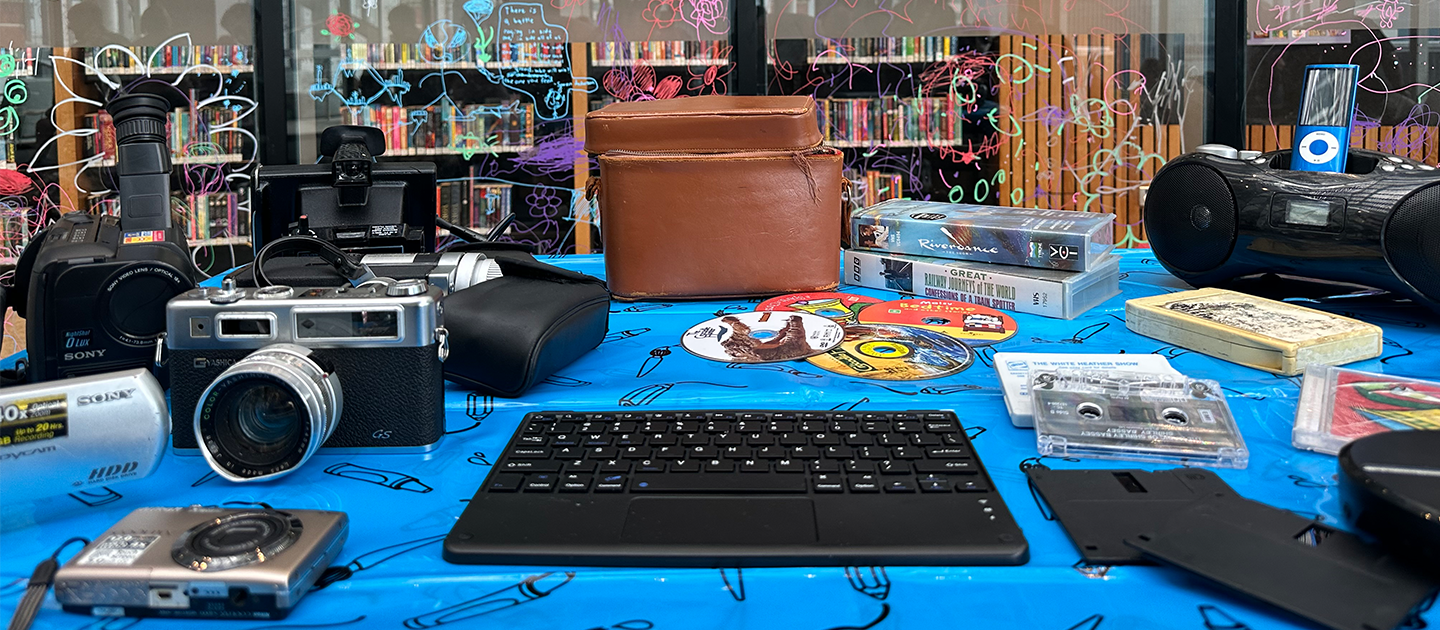 Table in the Library filled with retro tech and old fashioned equipment. 