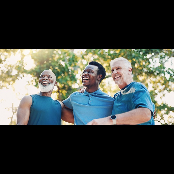 Senior men in blue shirts standing together in a park.