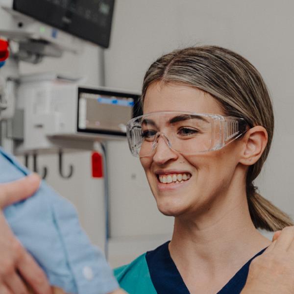 Female medical worker smiling and interacting with an elderly patient.