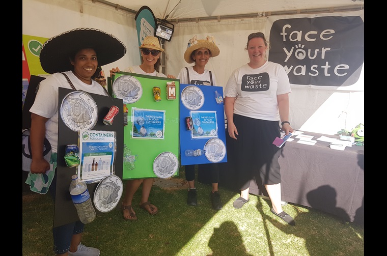 Four volunteers standing with face your waste signs.