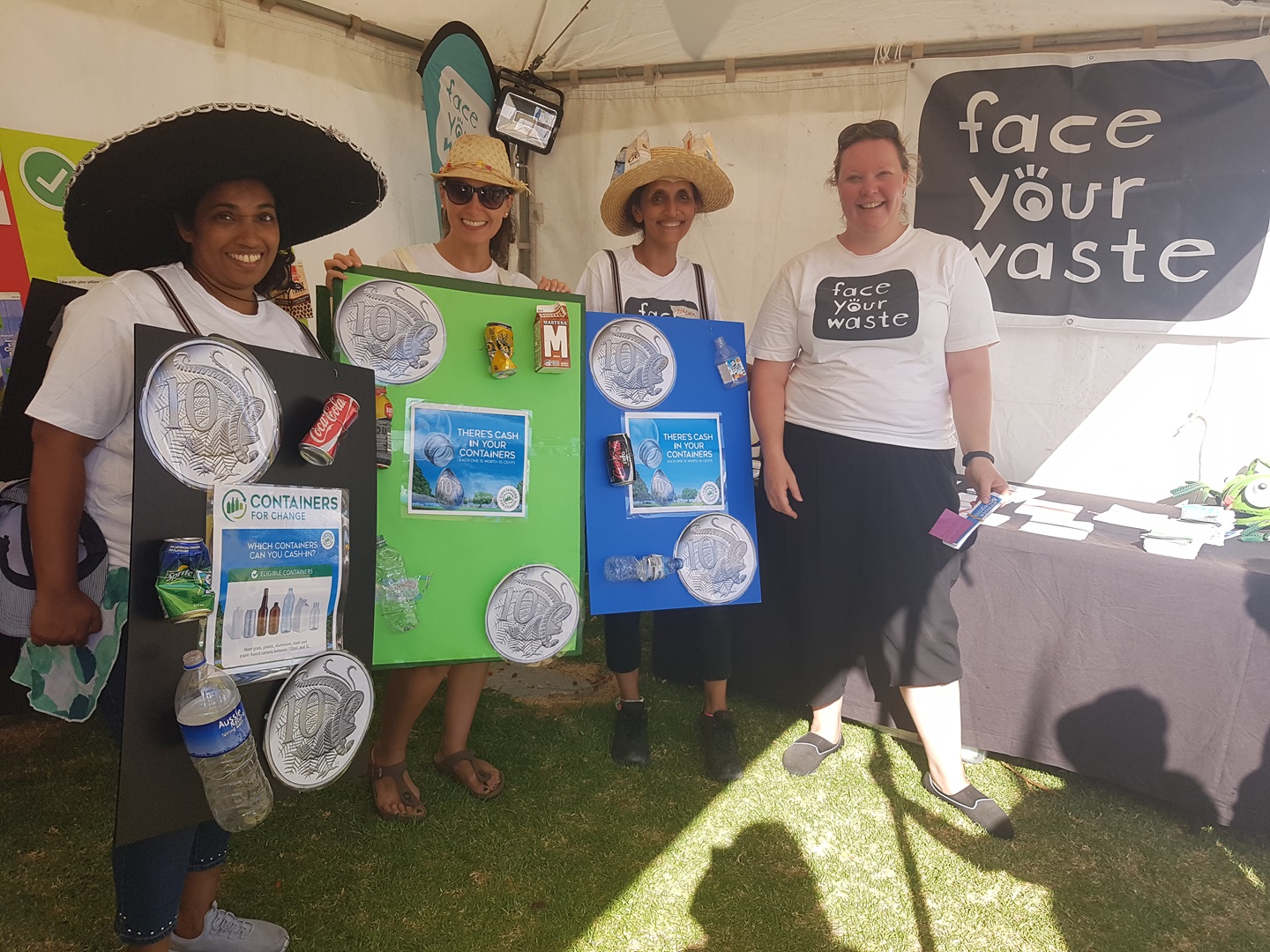 Four volunteers standing with face your waste signs.