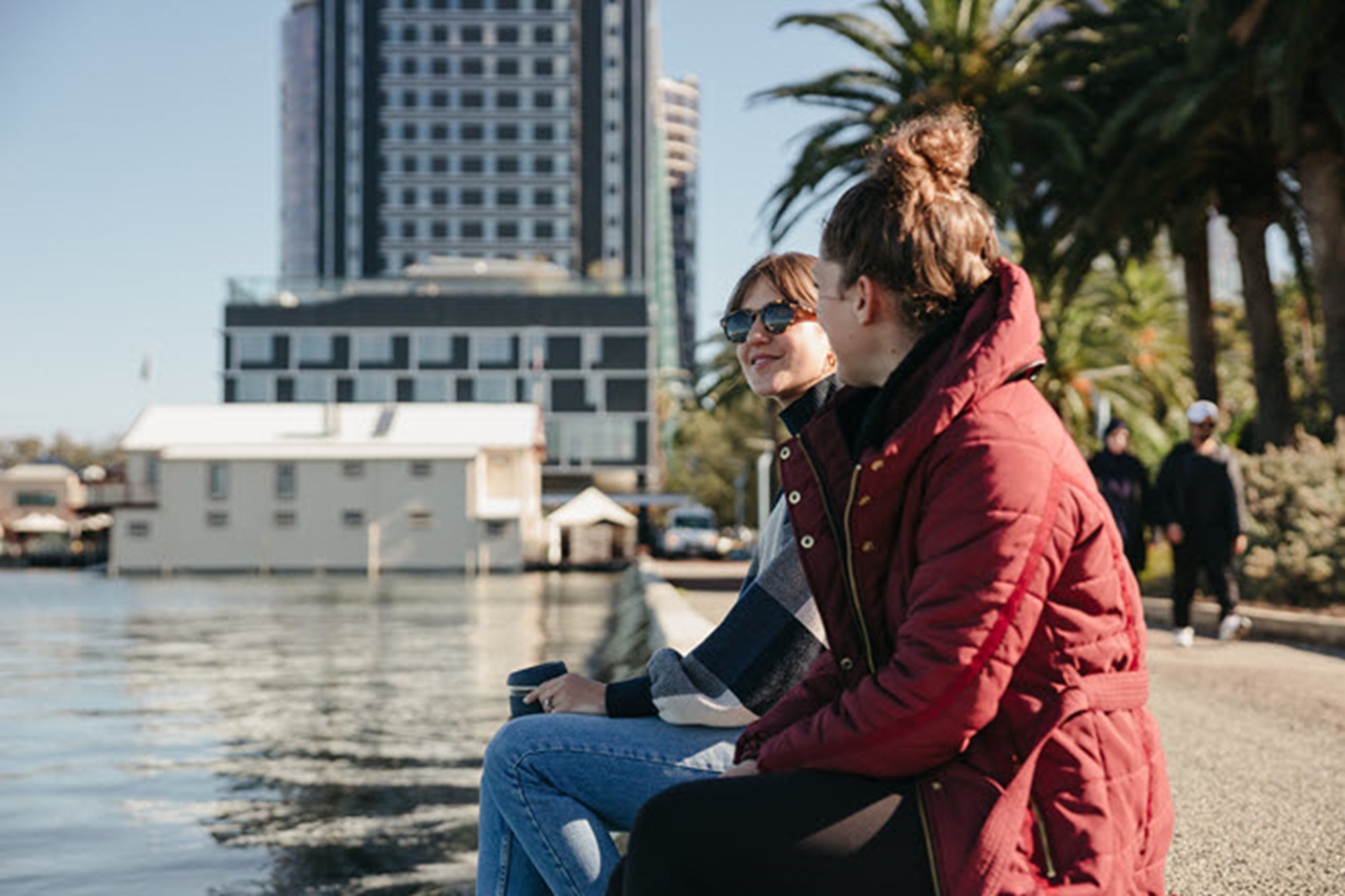 Two girls sit on the river
