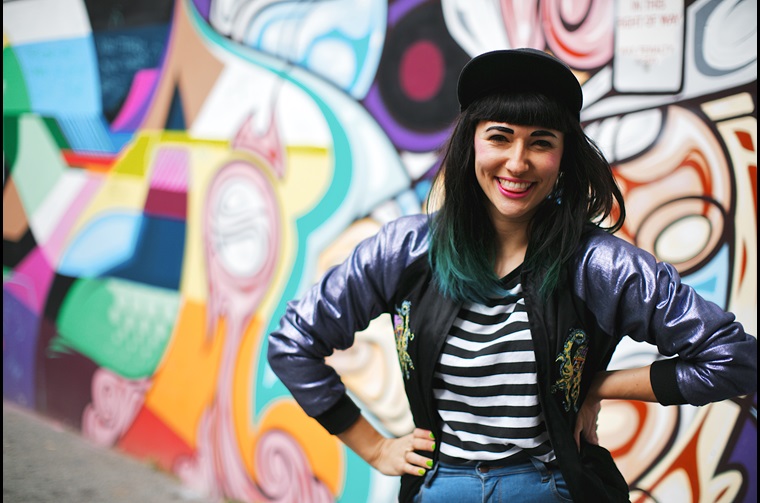 Girl smiling in front of artistic wall