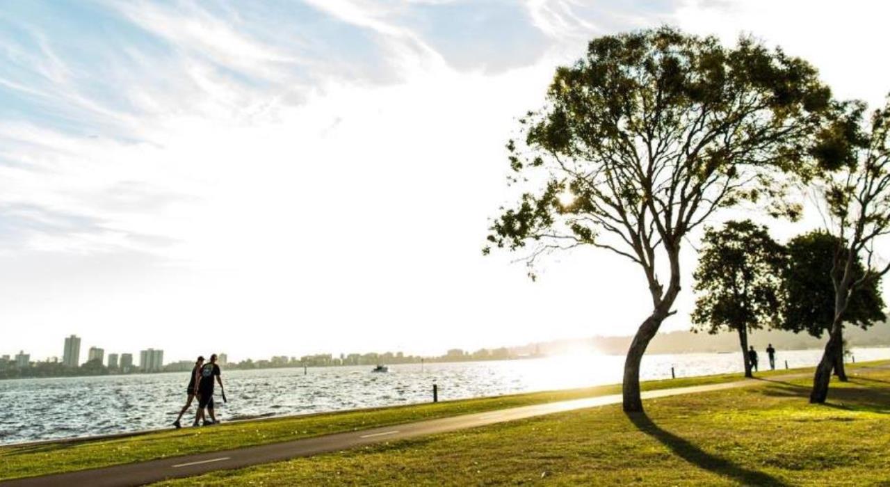 Swan River Foreshore Swan River Foreshore with walkers along the footpath and the sun shining, and some green trees