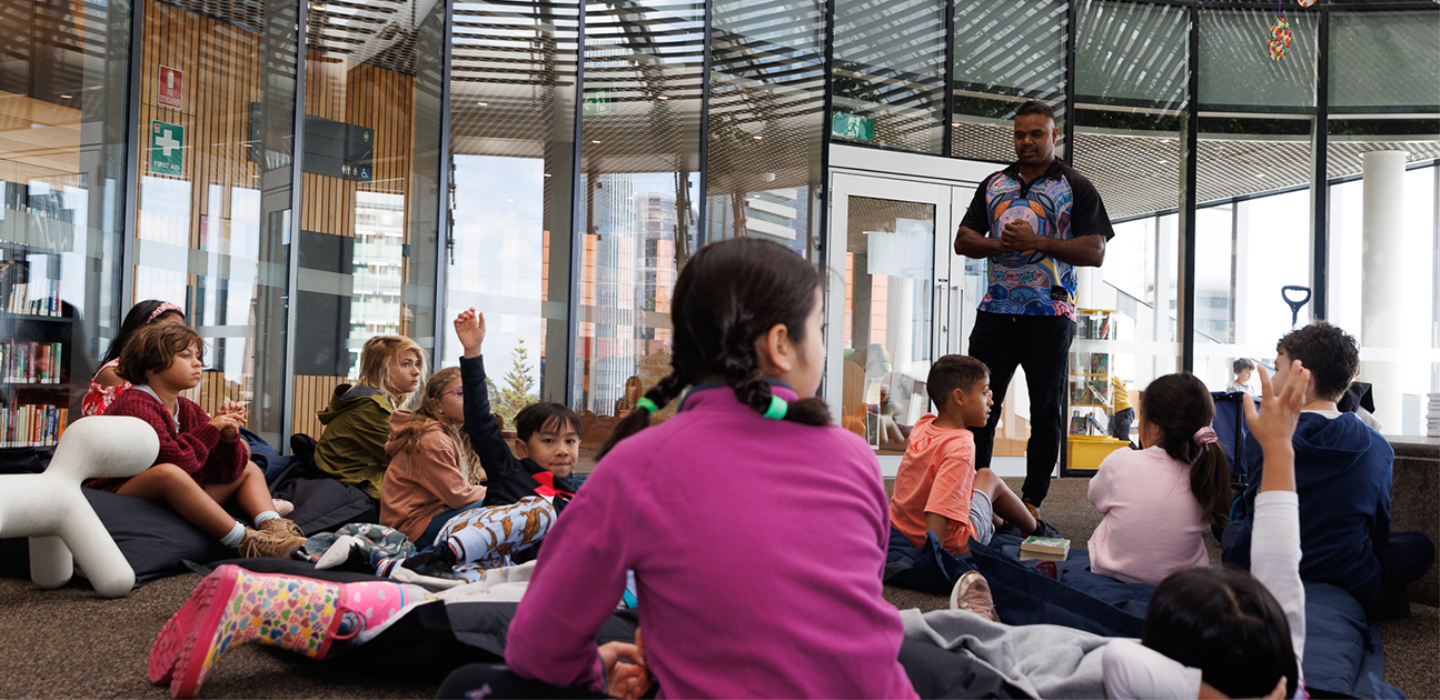 Children in the Tree area of the Library listening to Justin from Djurandi Dreaming