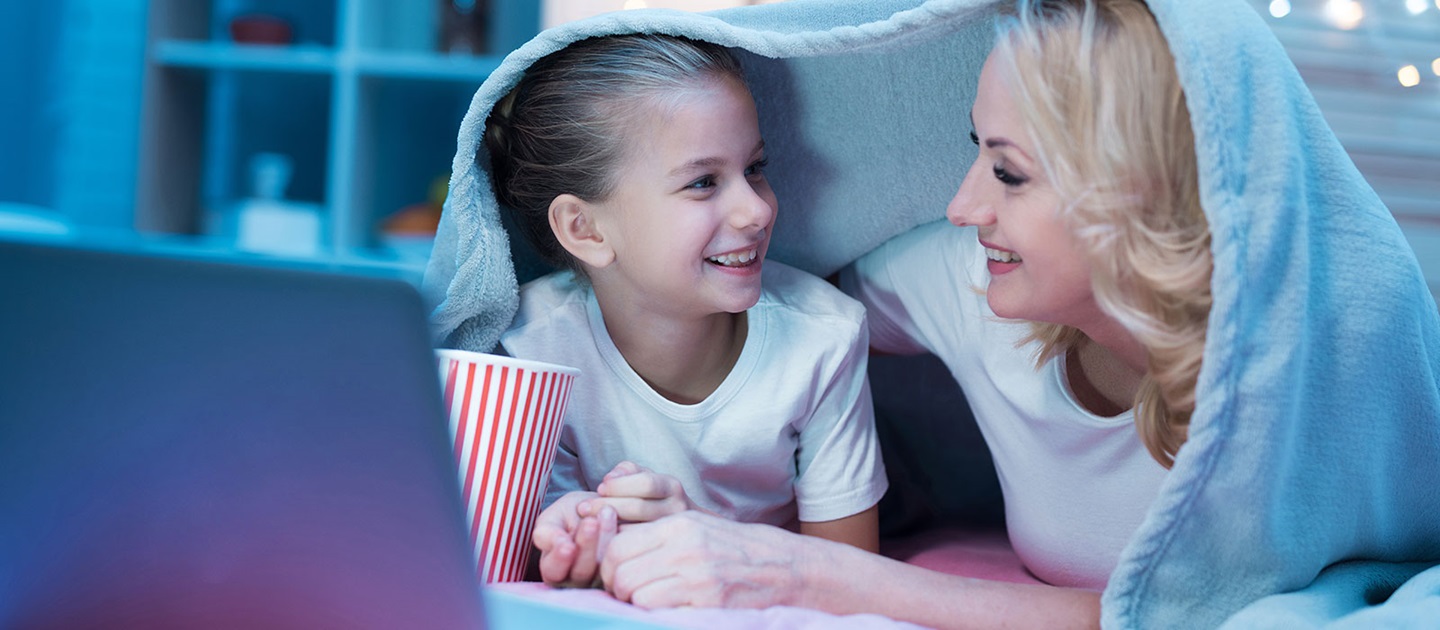 Mother and daughter watching movie on laptop at home