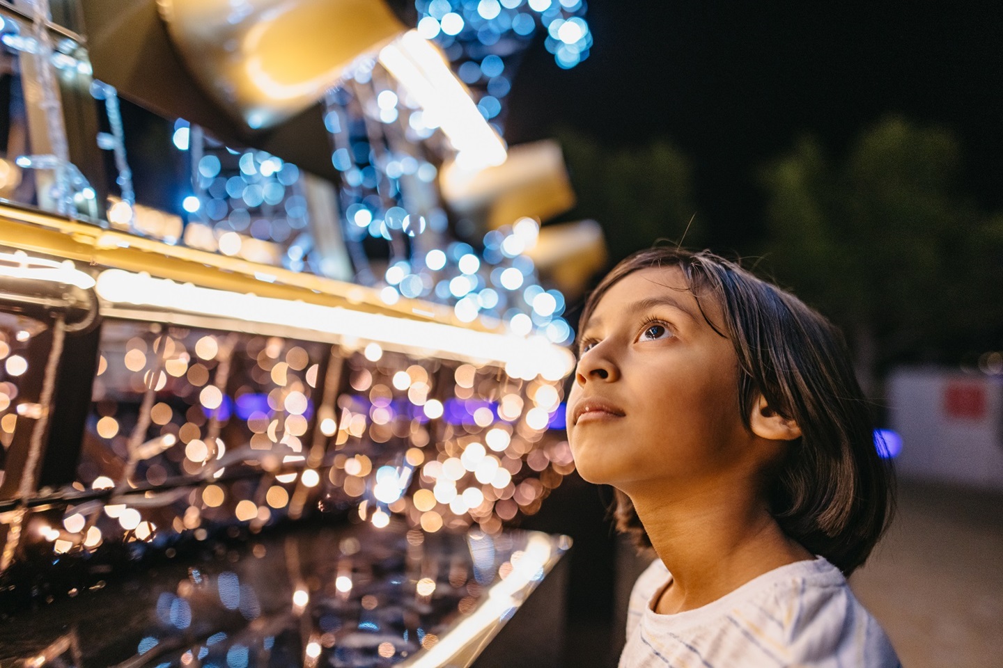 Child looking at Christmas Lights Trail installation 2023